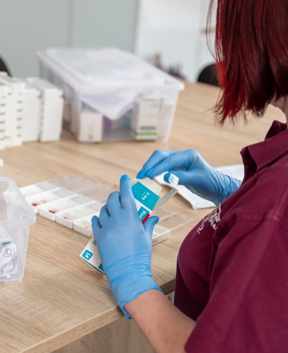 Mitarbeiterin des Pflegeteams Diana verteilt Medikamente
