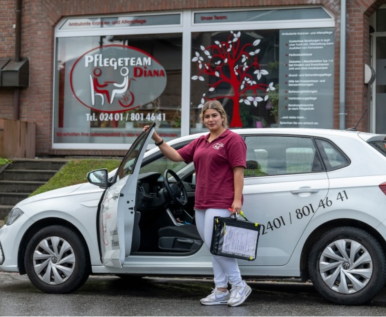 Mitarbeiterin des Pflegeteams Diana steigt aus Dienstwagen vor dem Büro
